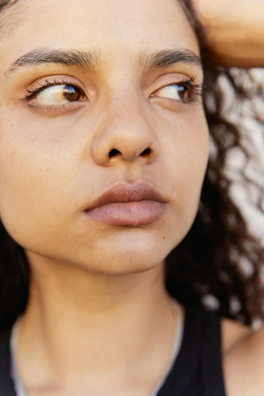 a close - up of a young woman's face with a combed hairstyle