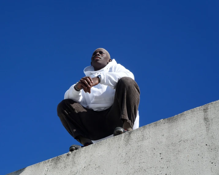 a man sitting on top of a cement slab