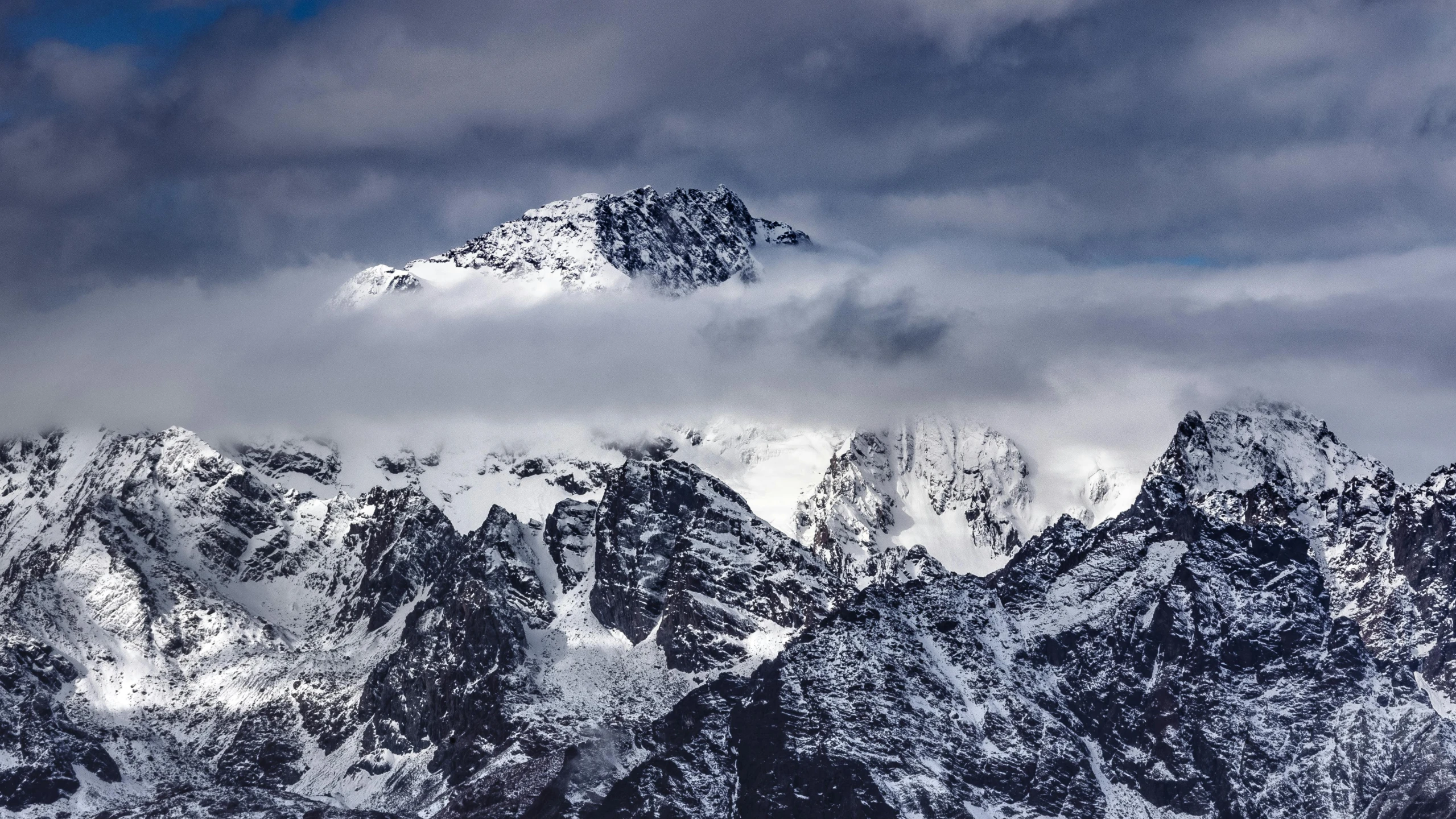 snowy mountains against the cloudy sky