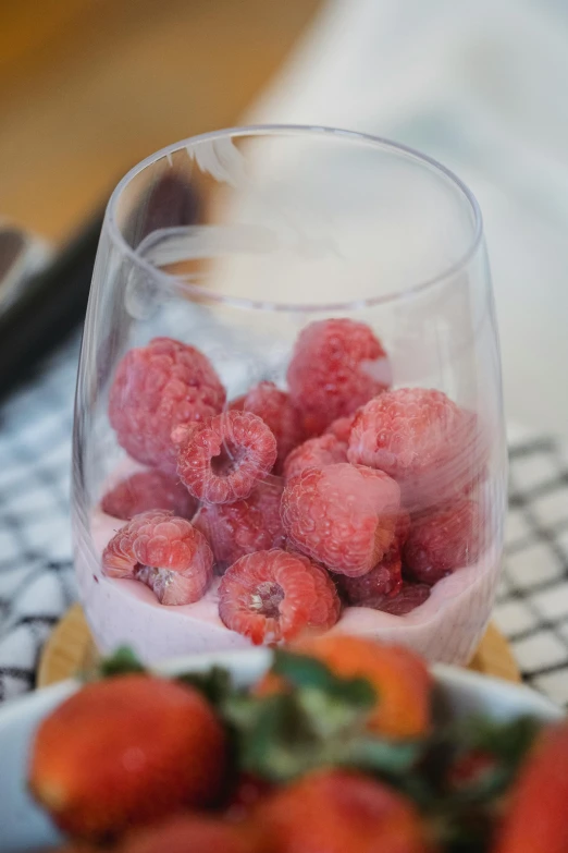 strawberrys are on the table next to a glass cup