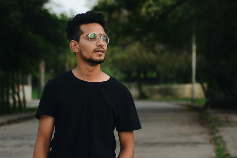 a man with glasses and hair wearing a black shirt