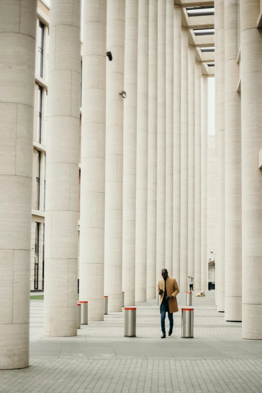 man standing next to white column in large building