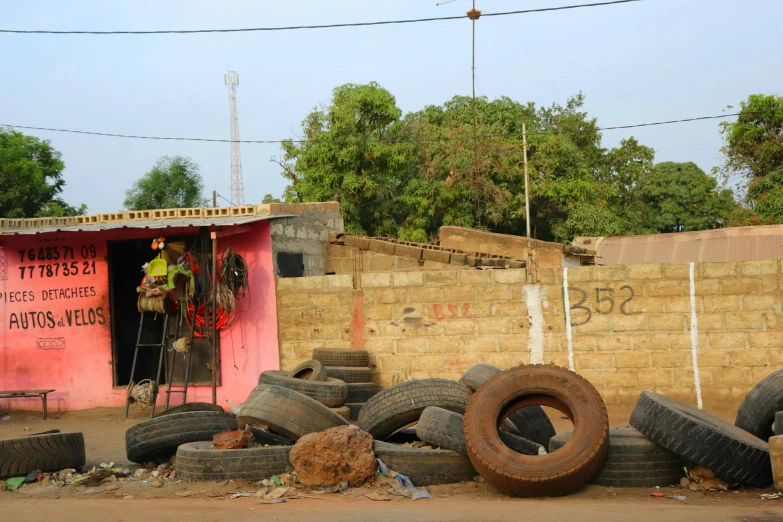 several tires piled up on the ground next to a wall