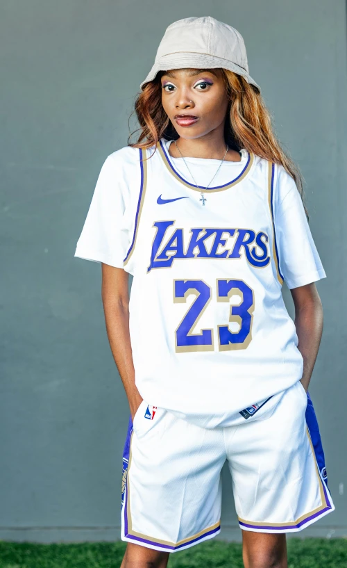 a beautiful woman standing next to a wall wearing a basketball uniform