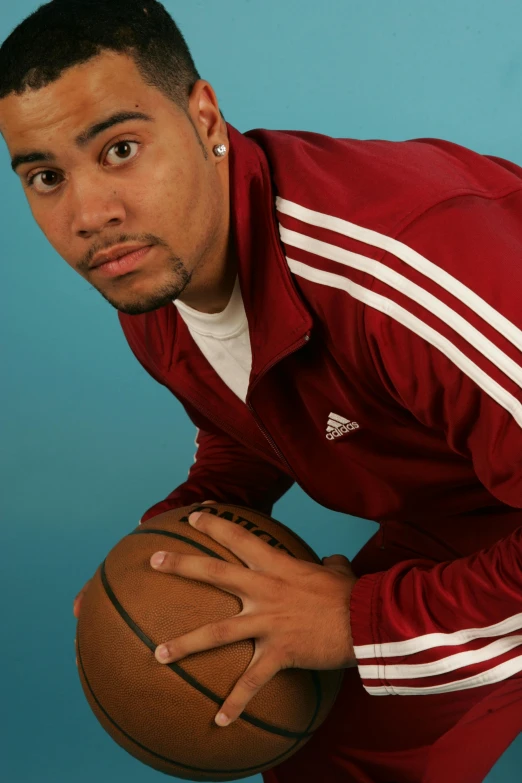 a male in a red sweatshirt is holding a basketball