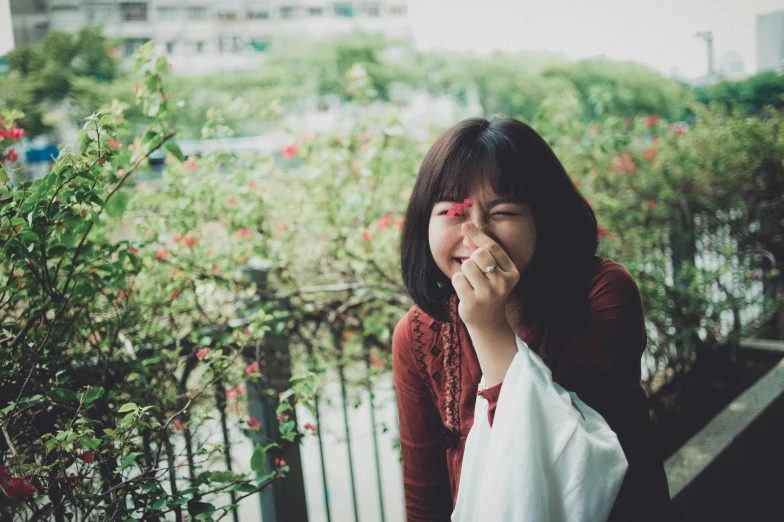 a girl in the rain blowing her nose