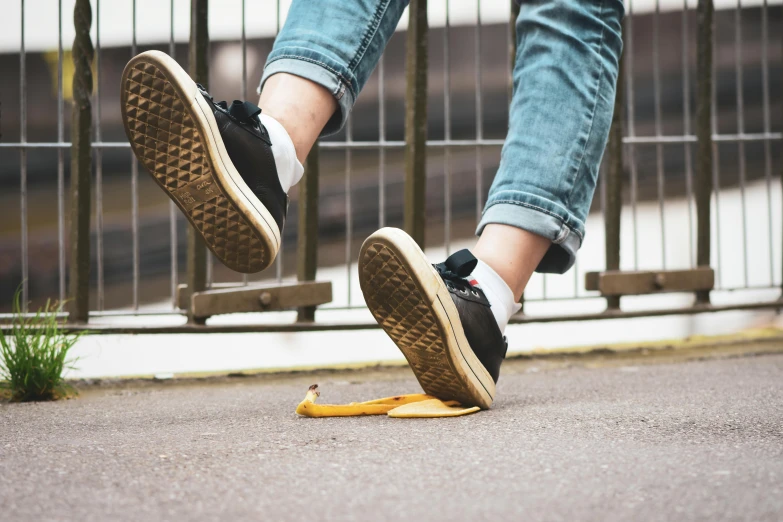 a pair of feet stepping on an upside down banana peel