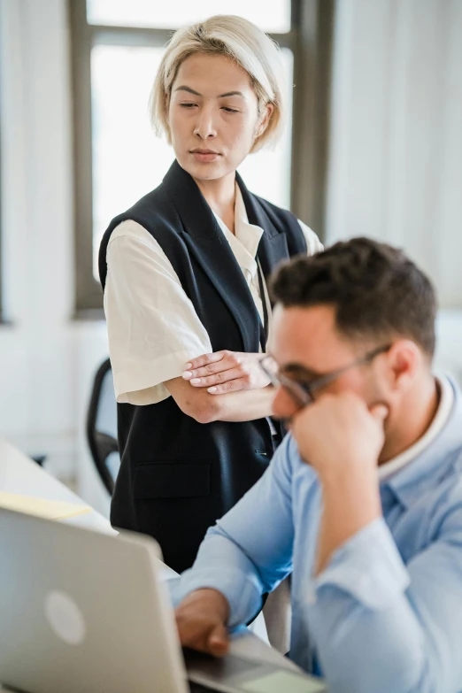 an old man and an older lady are both staring at a computer