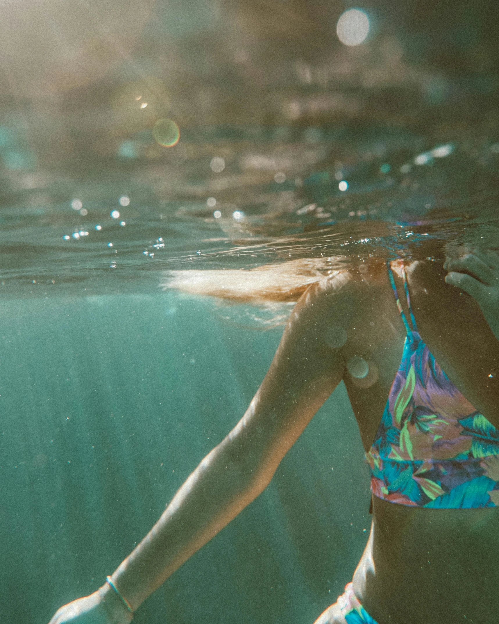 a woman's back under water in a bikini