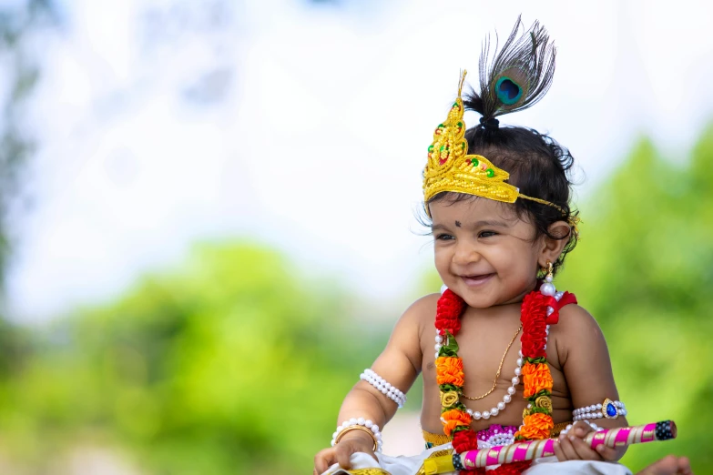 baby dressed in a colorful costume with beads and feathers