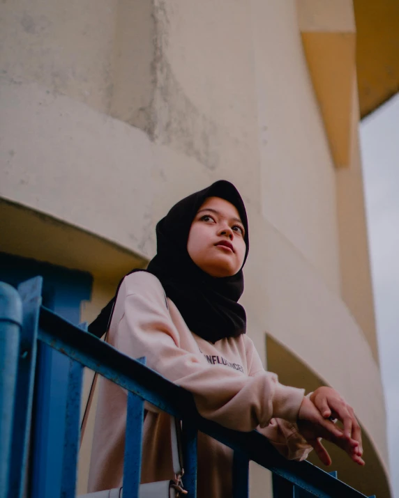 a young woman with a scarf looking out