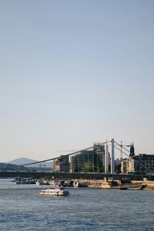 two boats floating in the water under the bridge