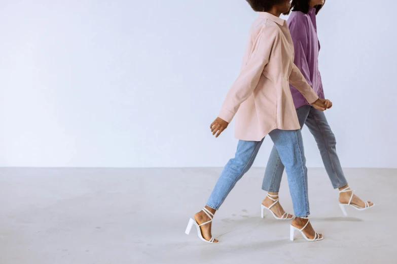 two women walking side by side on a gray ground