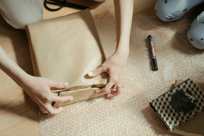 a person wrapping a bag and wrapping it into a package