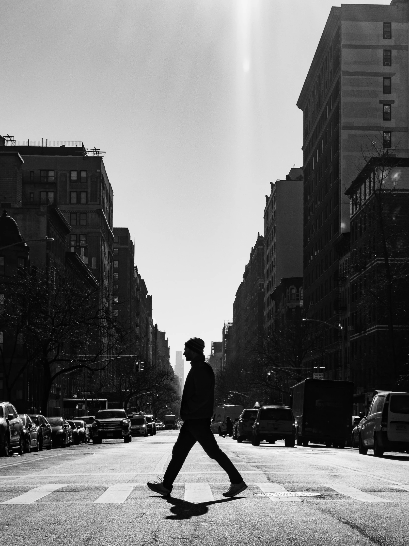 this black and white image is of man walking down a city street