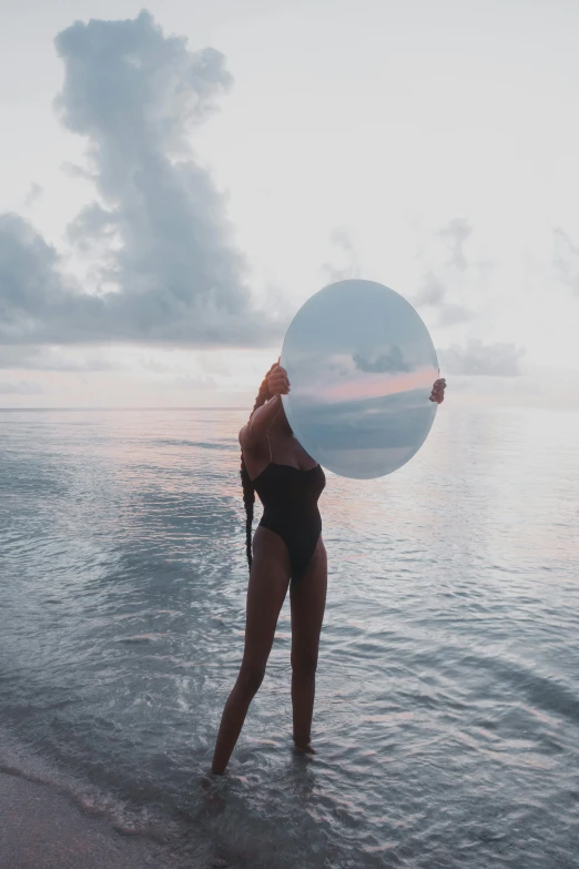 a woman standing in shallow water at the beach