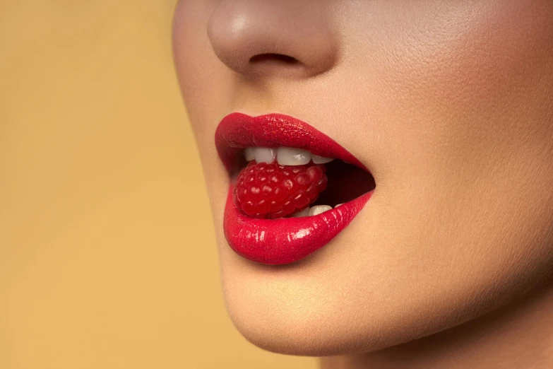 woman's lips with red lipstick and raspberries