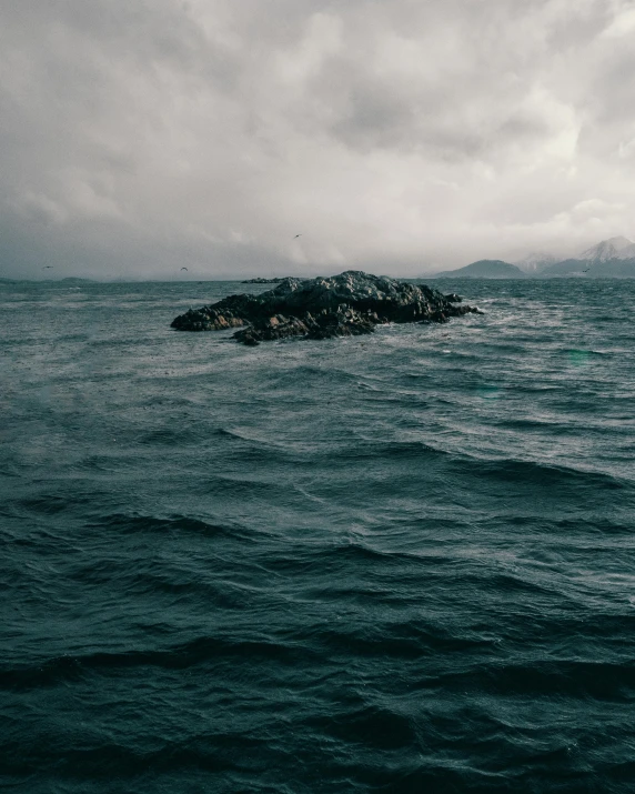 a lone rock in the middle of water