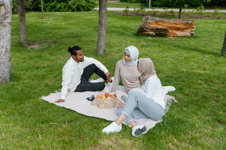 two people in hies on a blanket with an open basket