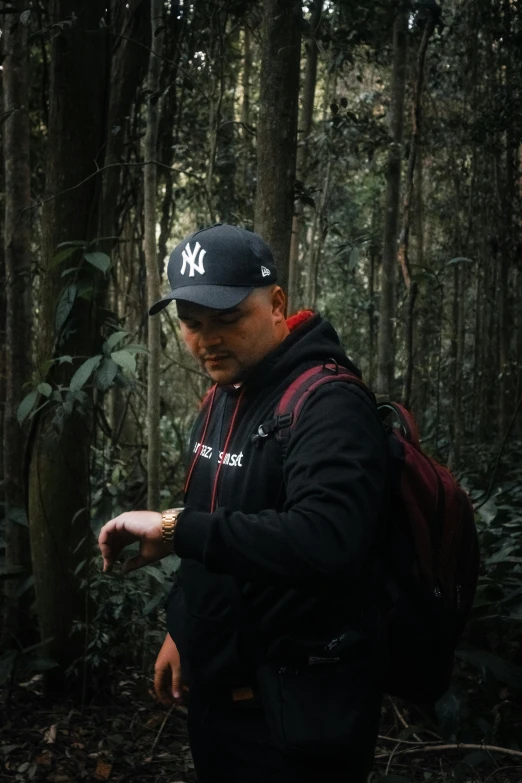 a man is pointing to soing while in the woods