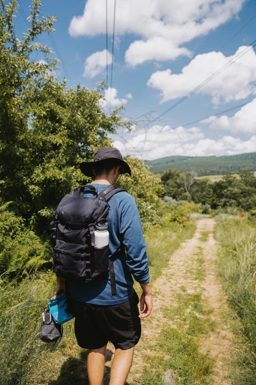 a man hiking through a lush green field