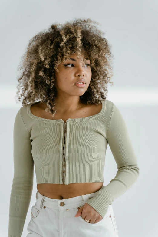a young woman with curly hair wearing a crop top