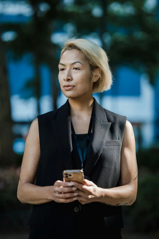 a woman holding a cell phone with a blue sky behind her