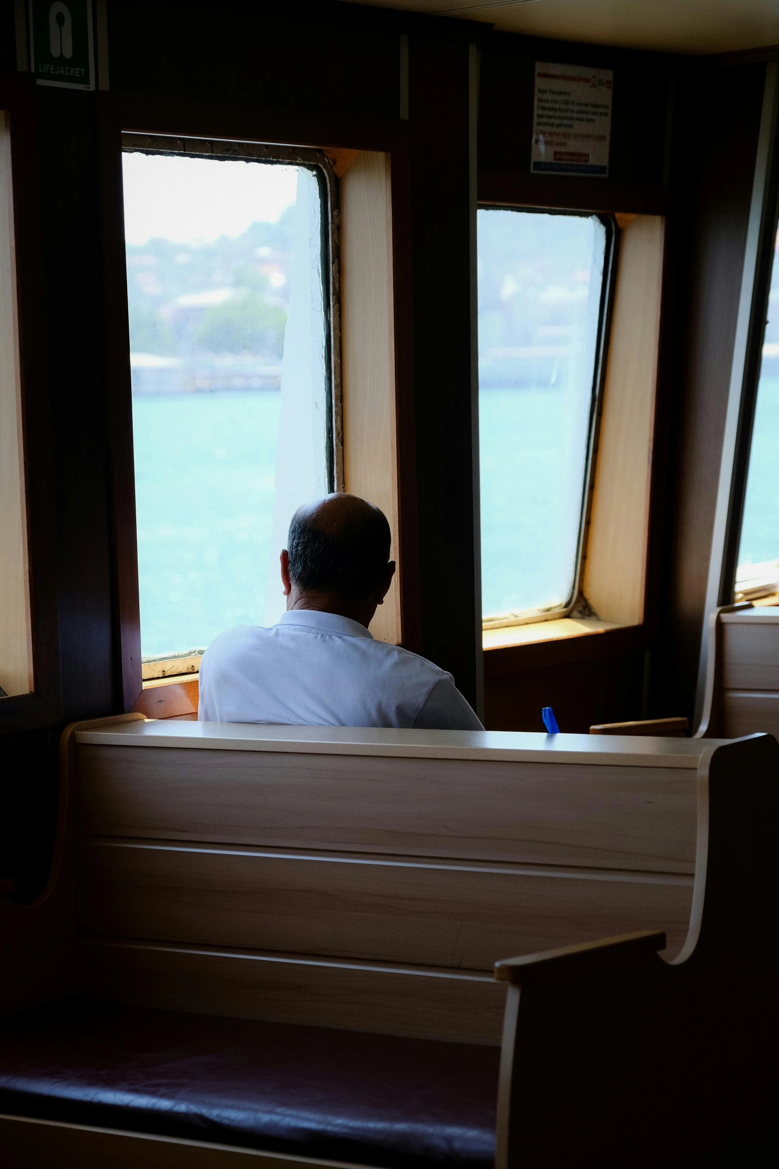 the view of a man looking out of a window from a ferry