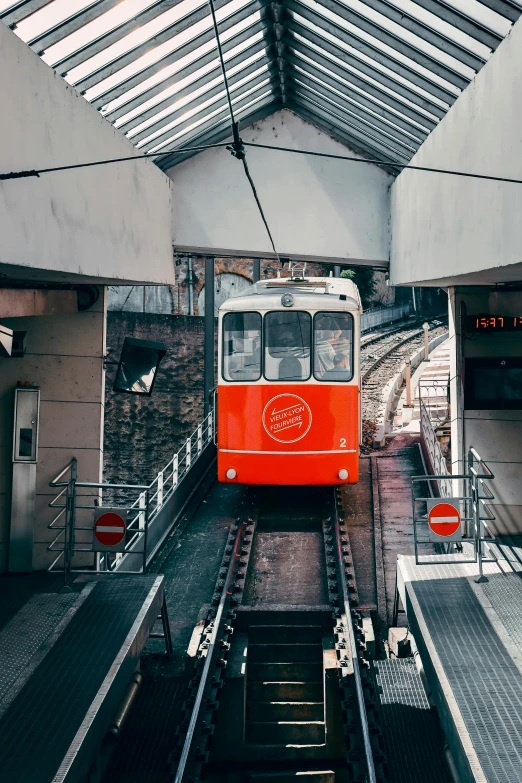 an orange trolley on the tracks in a building