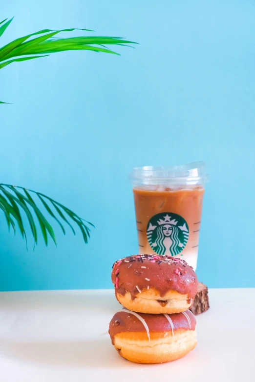 two donuts on a table near a cup of coffee