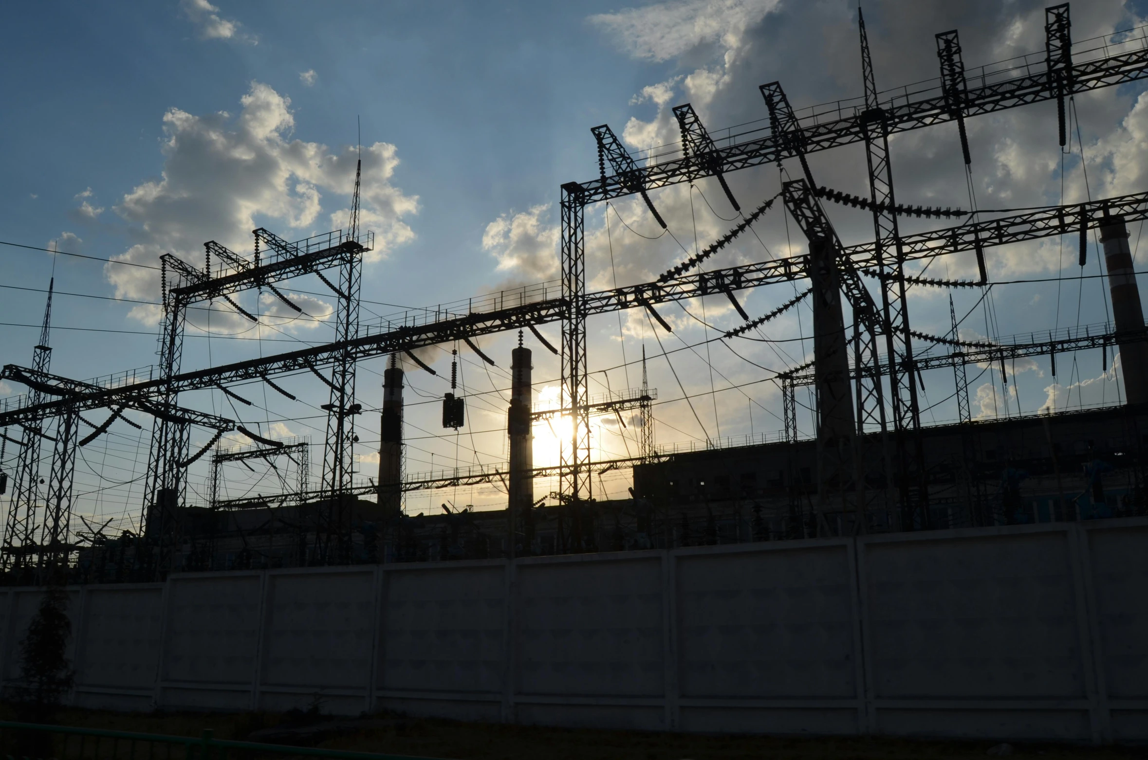 the sun shines through electrical wires in an electrical field