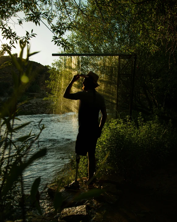 the person is standing by a river looking at a bird