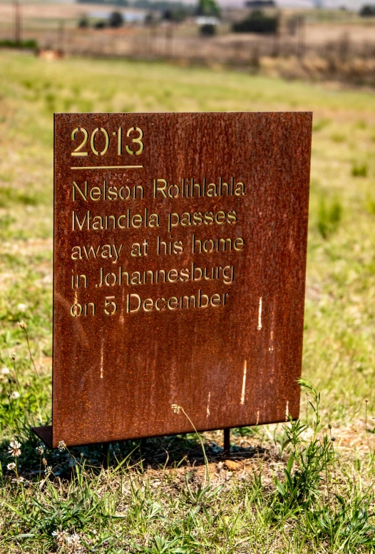 a wooden sign sitting on the side of a dirt road