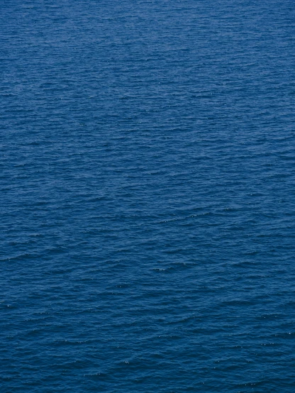 a large body of water that is blue with a boat in the distance