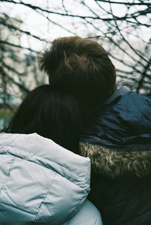 two people standing with the top half down, under tree nches