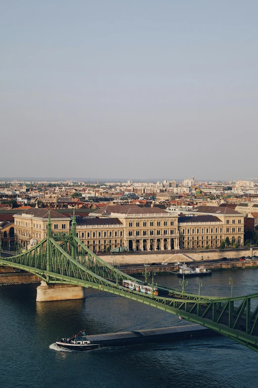 a large green bridge crosses over a river