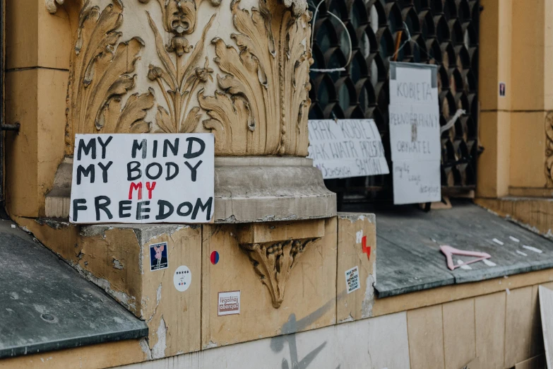 a sign on the corner of an old building that reads, my mind my body my freedom