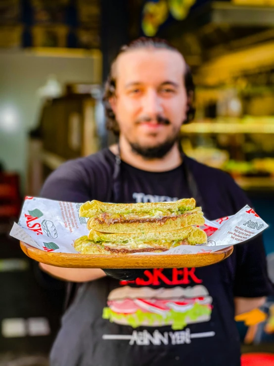 a man holds a tray of sandwiches that he has been holding in his hands