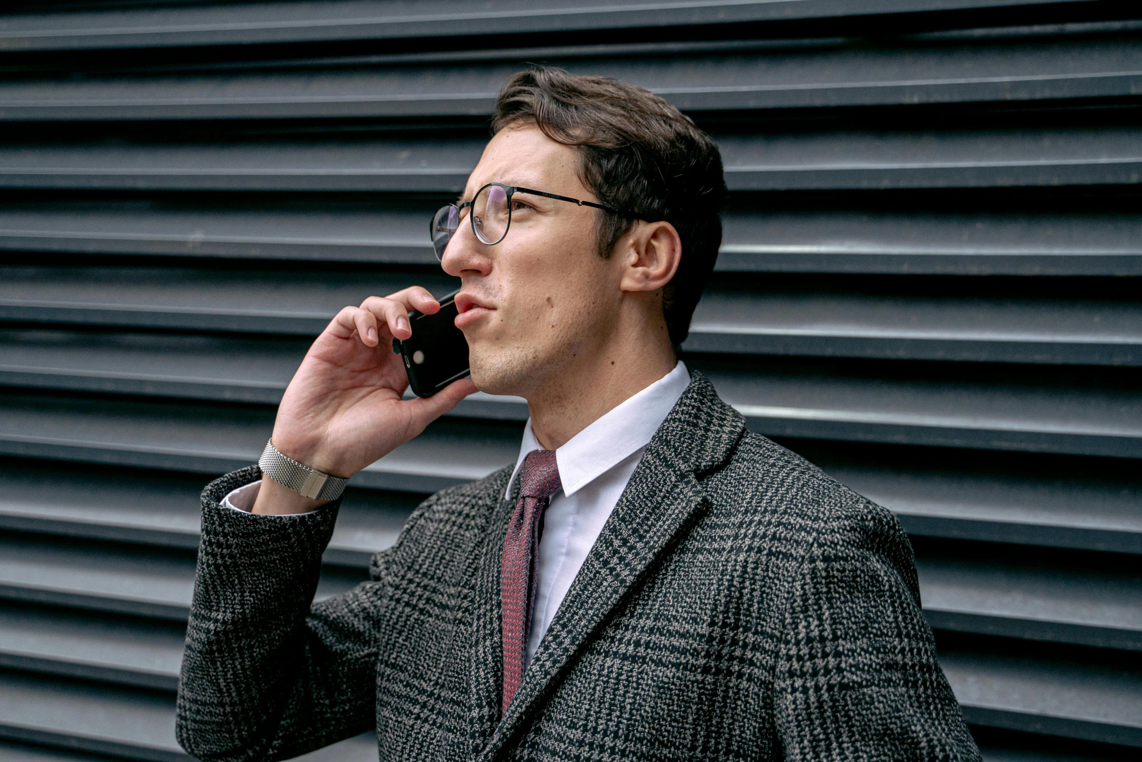 a man with glasses is talking on his cell phone