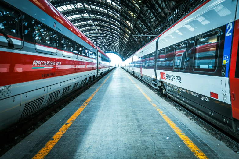 a long red and white train in a large tunnel