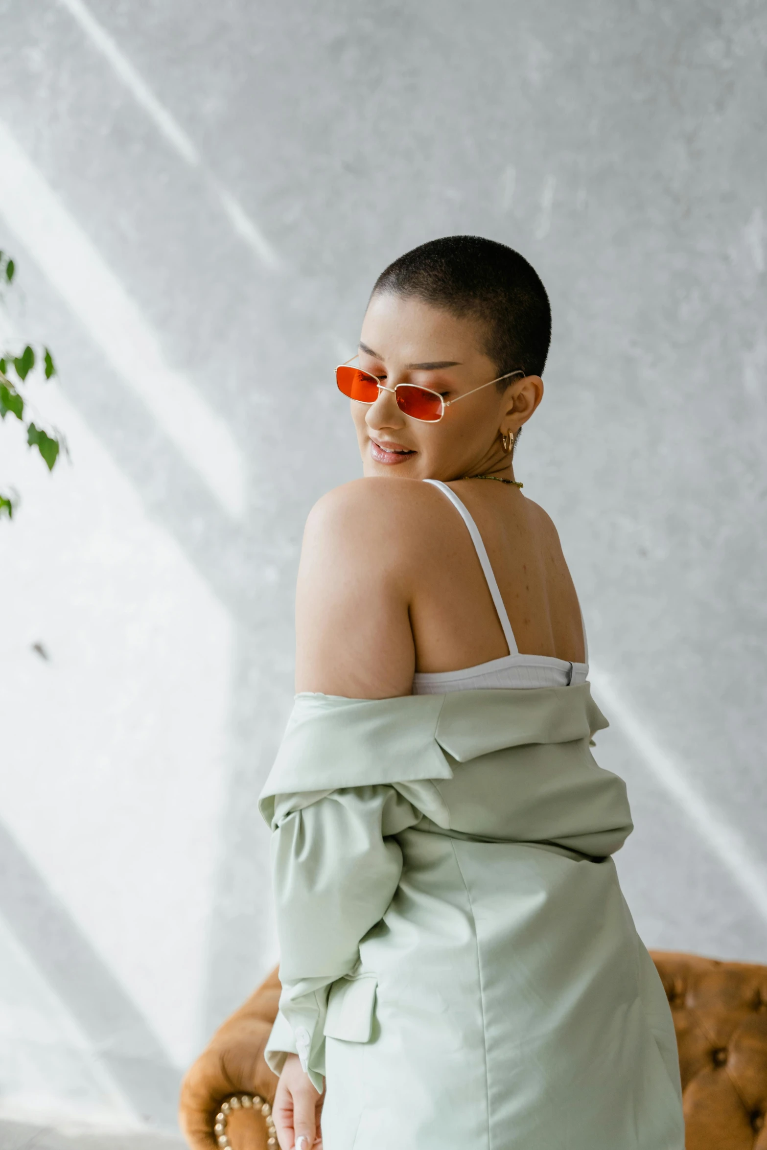 a young woman in sunglasses looking back with an off shoulder top