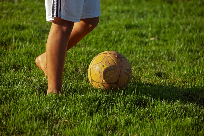 a soccer ball on the grass and a person walking away