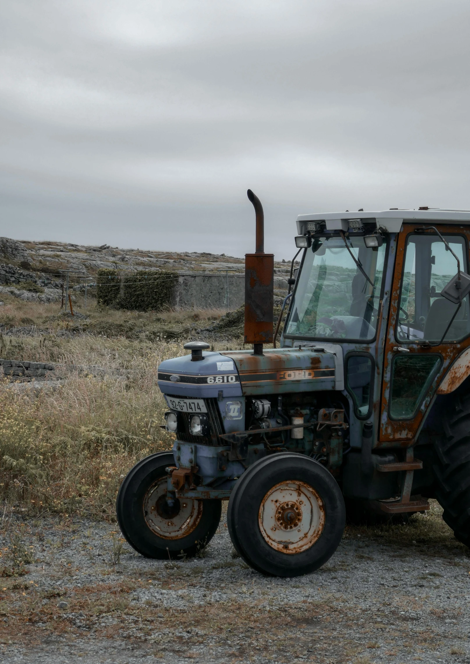 an old tractor sitting on the ground by itself