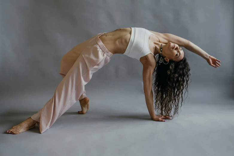a woman is doing a handstand against a grey background