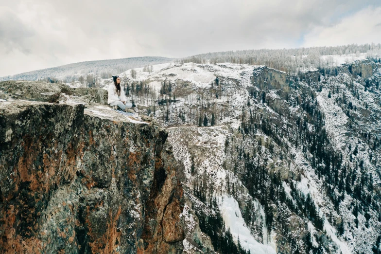 a person standing on top of a mountain with mountains in the background