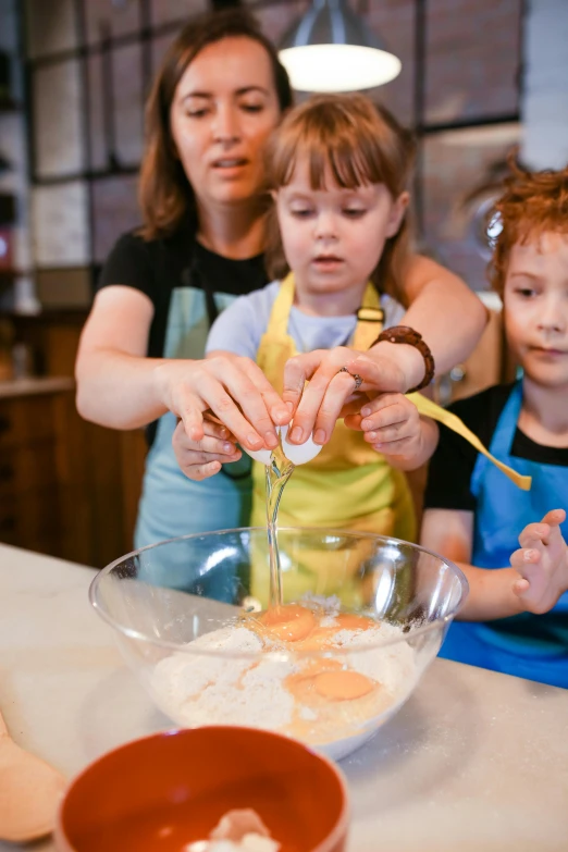 a woman and two children preparing food together