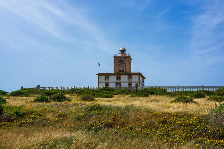 a building on top of a hill in a field