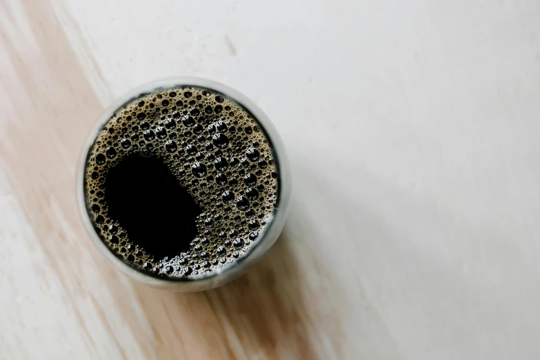 a cup on a white table is filled with liquid