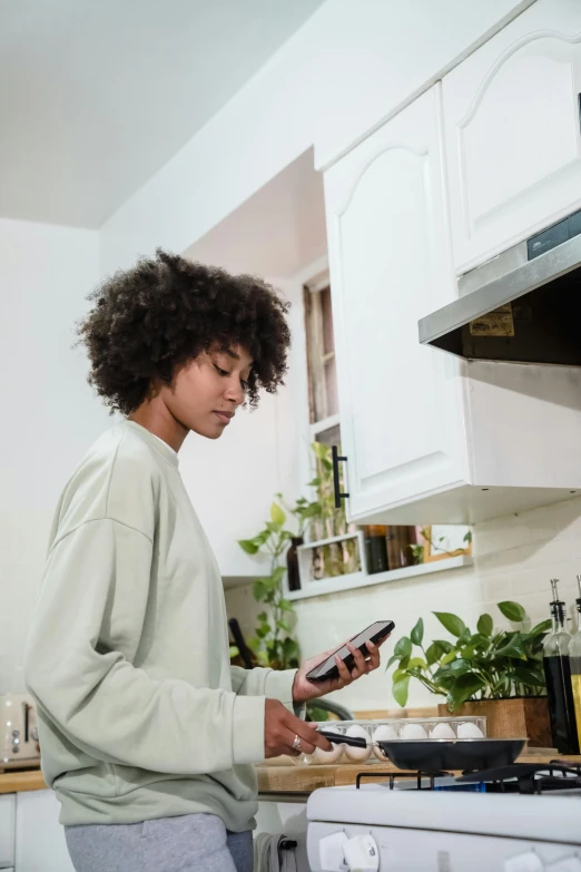 a woman holding a spoon in a kitchen