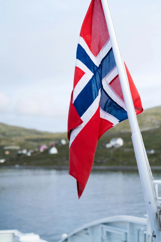 the norwegian flag waving on a boat in a body of water